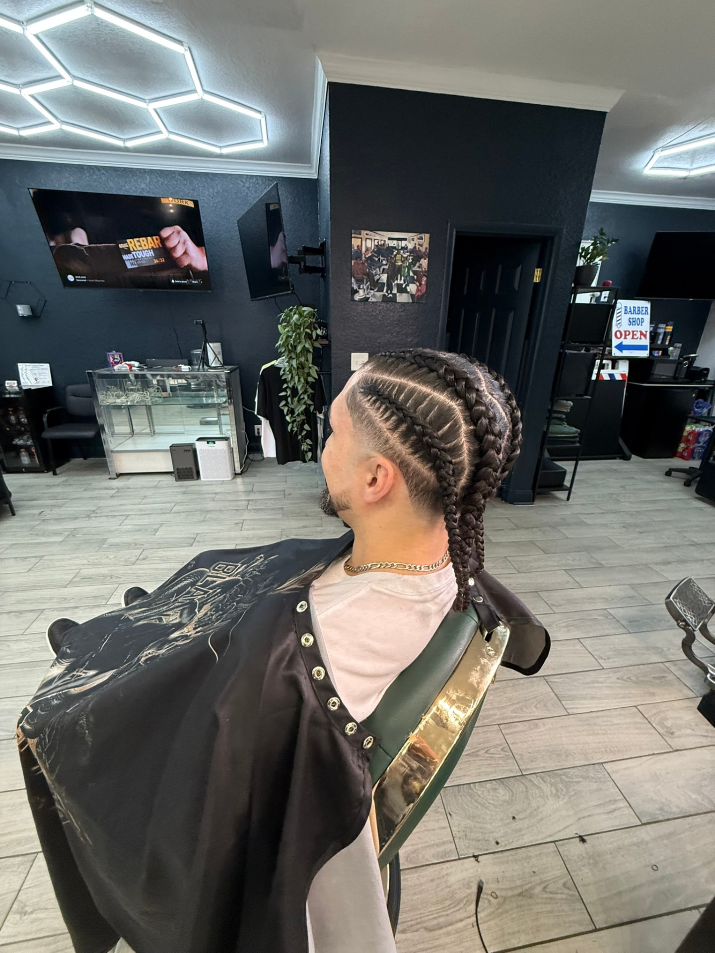 Cornrows with clean fade — side profile under hex lights