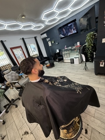 Client in gold barber chair watching the TV