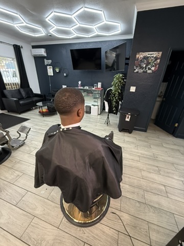 Clean low fade — back view in the shop